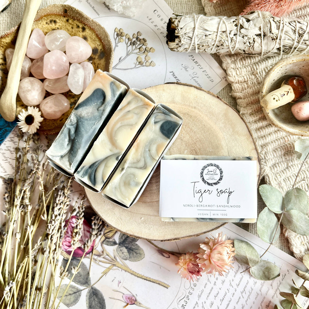 Three bars of Tiger soap on a wooden board with decorative elements like flowers and stones.